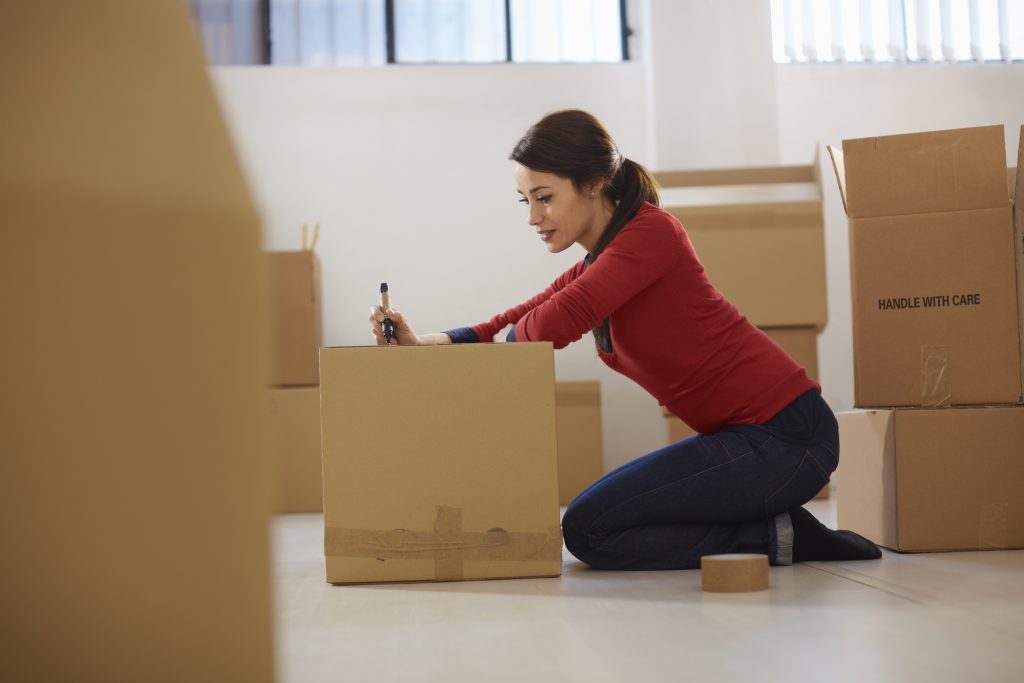 Lady labeling a moving box